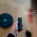 Hand met een afstandsbediening voor de robotstofzuiger, met tekst "Ook te bedienen met afstandsbediening".