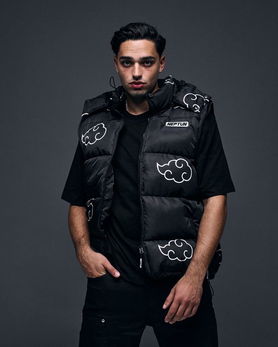 Model in zwarte puffer bodywarmer met witte wolkenprint, met handen in zakken.