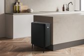 Matzwarte prullenbak met deksel, 80cm hoog, 53,4cm breed en 32,4cm diep, met slanke poten, in een keuken.