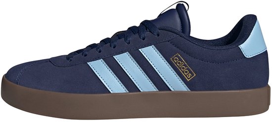 Vue latérale d'une basket Adidas bleu marine avec bandes bleu clair et semelle marron.
