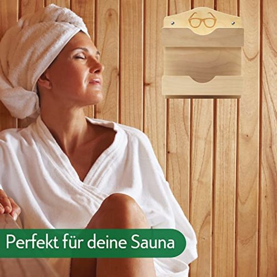 Houten brillenhouder met bril-icoon, opgehangen in een sauna. Een vrouw in badjas ontspant.