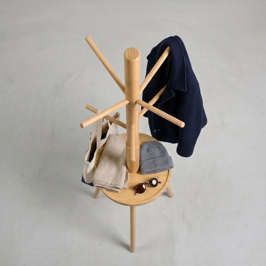 Houten kapstok met jas, muts, zonnebril en tas op het ronde plateau.