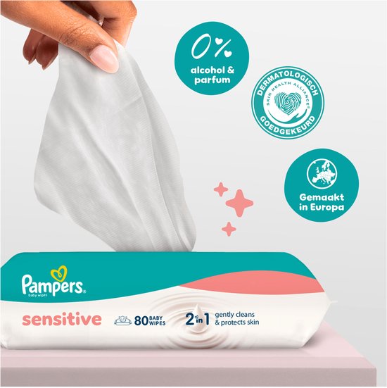 Une main prend une lingette Pampers Sensitive. "0% alcool & parfum" et "Approuvé dermatologiquement".