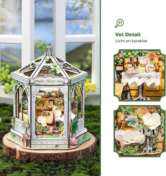 Miniatuur Windsor bloemenhuis met vrouw en gedetailleerde bloemstukken.