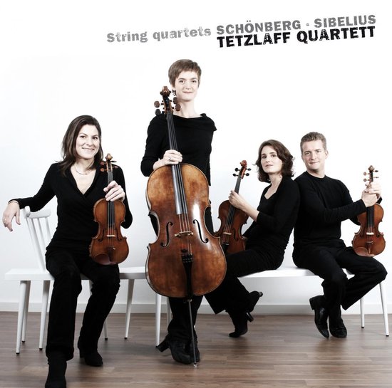 Vier musici van het Tetzläff kwartet in zwarte kleding met hun instrumenten. Een cellist staat centraal.