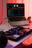 DJControl Inpulse 200 MK3 controller met verlichte pads op een bureau, met laptop en koptelefoon.