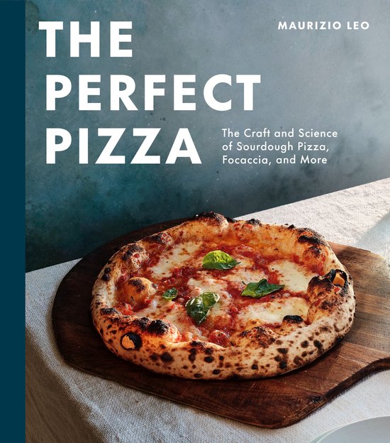 Boek "The Perfect Pizza" met een close-up van een perfect gebakken pizza met mozzarella en basilicum op een houten plank.