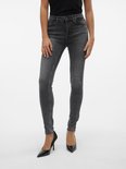 Model in strakke grijze jeans met hoge taille.