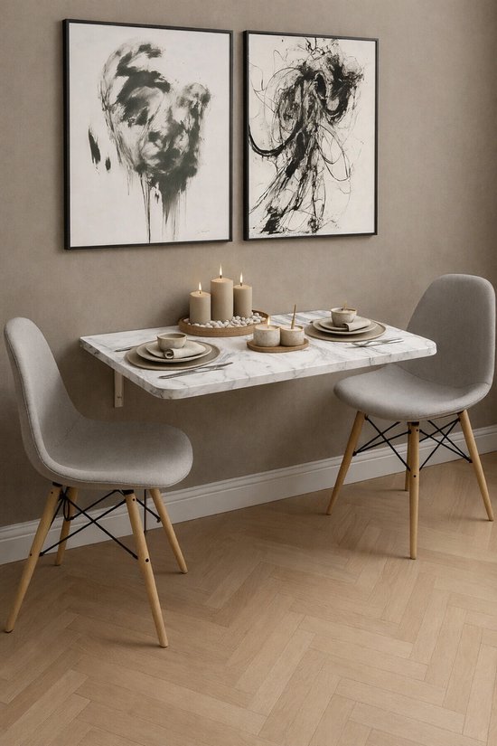 Klaptafel met wit marmerlook blad, staand op een taupe muur, met twee grijze stoelen.