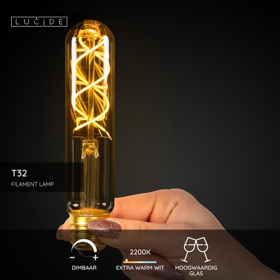 Une main avec des ongles pailletés tient une ampoule ambrée T32 LED à filament avec un filament en spirale. 2200K. Blanc extra chaud et dimmable.
