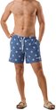 Man staat met handen in de zakken, draagt blauwe zwemshorts met strepen en schildpadprint.