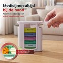 Witte medicijndoos voor 7 dagen. Een hand pakt een dagdoosje met medicijnen eruit. "Grote letters zijn goed leesbaar".