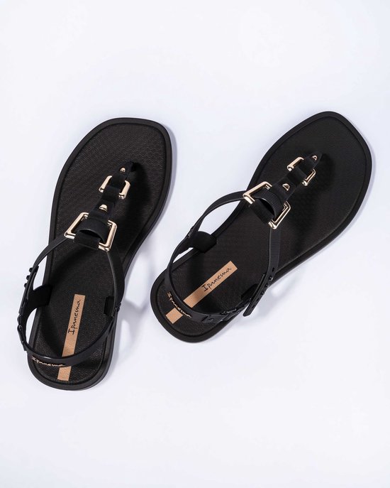 Zwarte Ipanema teenslippers met goudkleurige gespen, bandjes en logo.