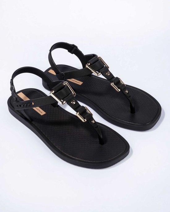 Zwarte Ipanema slippers met gouden gespen en verstelbare enkelband.