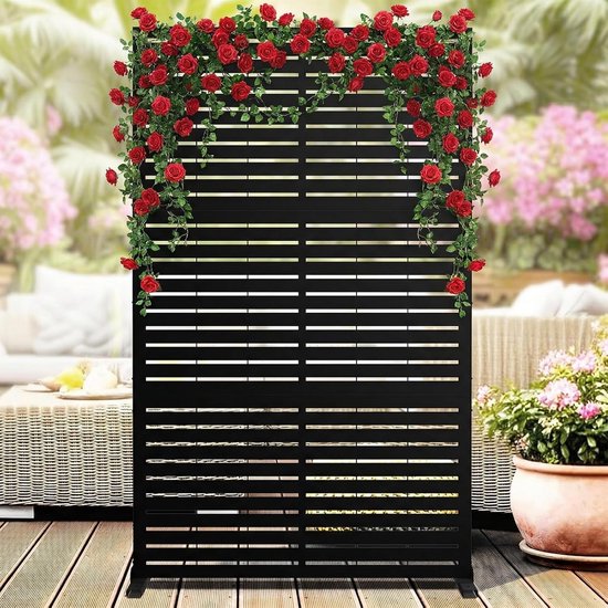 Zwarte schermen met horizontale lamellen, versierd met rode rozen. Terras met tuinmeubilair.