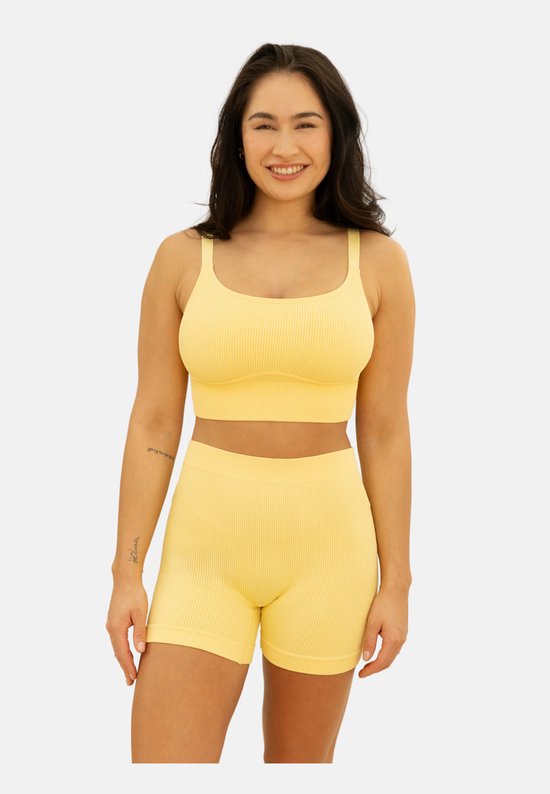 Model met een gele, nauwsluitende bustier en bijpassende short met ribbelstof.