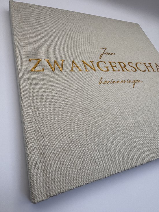 Crème invulboek 'Zwangerschap herinneringen' met gouden tekst op de voorkant, close-up van de textuur.