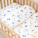 Wit beddengoed met safari dierenprint in een houten ledikant.