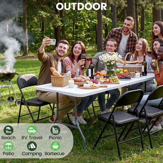 Een groep vrienden geniet van een picknick in het bos rond een witte klaptafel. Ze maken selfies en genieten van eten en drinken.