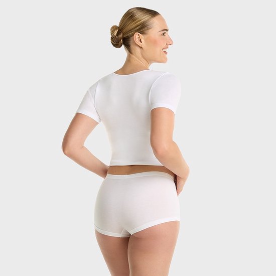 Model draagt witte crop top en witte short, zichtbaar van achteren.