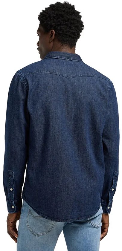 Achterkant van een man in een blauw spijkerhemd met lange mouwen, twee borstzakken met knoopsluiting.