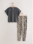 Een donkergrijs T-shirt met korte mouwen en een luipaardprint broek hangen aan hangers.