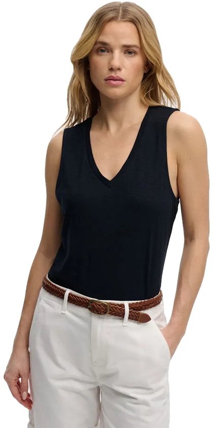 Vue de face du mannequin portant un t-shirt noir sans manches à col en V, un pantalon blanc et une ceinture marron.