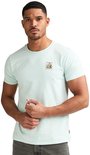 Man in lichtgroen T-shirt met een opgedrukte postzegel met bloemen op de linkerborst.