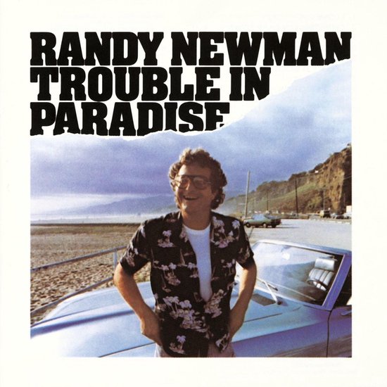 Randy Newman, Trouble in Paradise albumhoes met Randy Newman in Hawaii-shirt, witte t-shirt, jeans en zonnebril, staand bij een auto aan het strand.