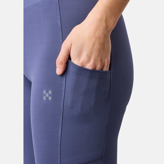 Detail van een paarse legging met steekzak en een discreet logo.