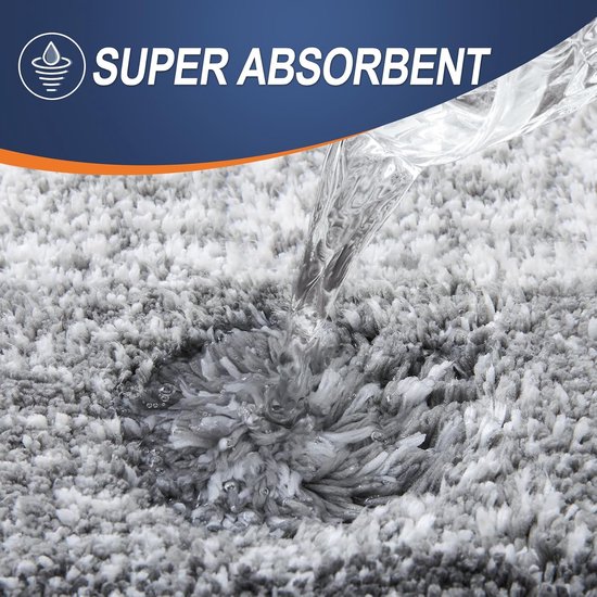 Water stroomt op een zachte, absorberende grijze badmat met de tekst 'SUPER ABSORBENT'.