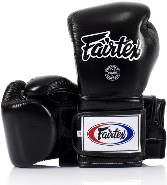 Zwarte Fairtex bokshandschoenen, op elkaar geplaatst. Logo's en wit stiksel zichtbaar.