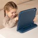 Een jong meisje met vlechten kijkt naar een blauwe tablet in een hoes met standaard.
