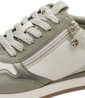 Detail van een groene en witte Tamaris sneaker met veter en ritssluiting met Tamaris logo.