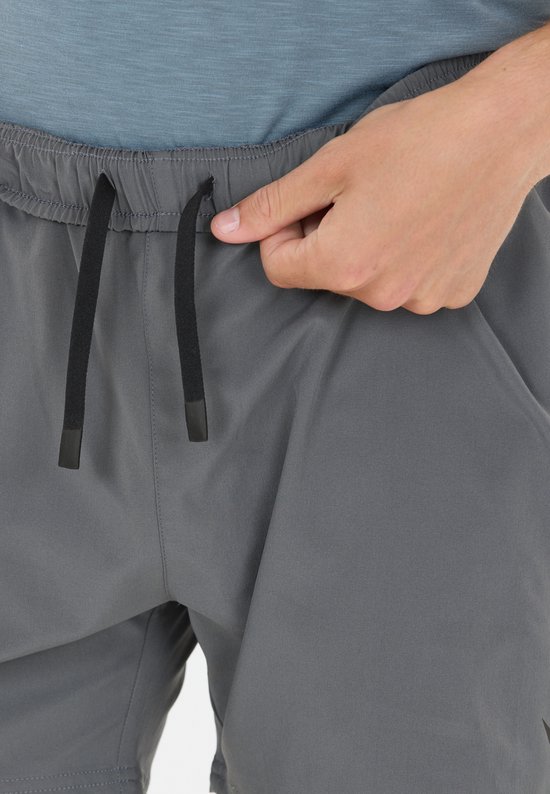 Close-up van de tailleband van een grijze sportshort met zwart binnenbroekje en zwarte koordjes.