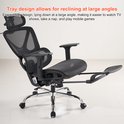 Zwarte ergonomische bureaustoel met uitklapbare voetensteun, liggend in een hoek. Tekst: 'Tray design allows for reclining at large angles'.