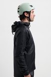 Man in profiel, met een zwarte fietsjas en een lichtgroene helm.