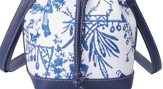 Detail van donkerblauwe emmer tas met wit canvas en blauw Chinoiserie patroon.