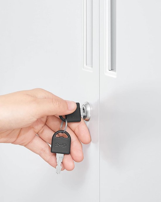 Hand met sleutels die een slot op een witte metalen kast probeert te openen.