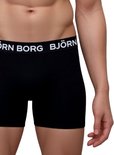 Detail van een zwarte Björn Borg boxer met witte merknaam op de band, gedragen door een man.