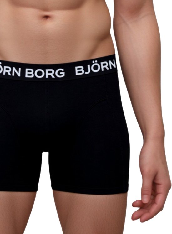 Detail van een zwarte Björn Borg boxer met witte merknaam op de band, gedragen door een man.