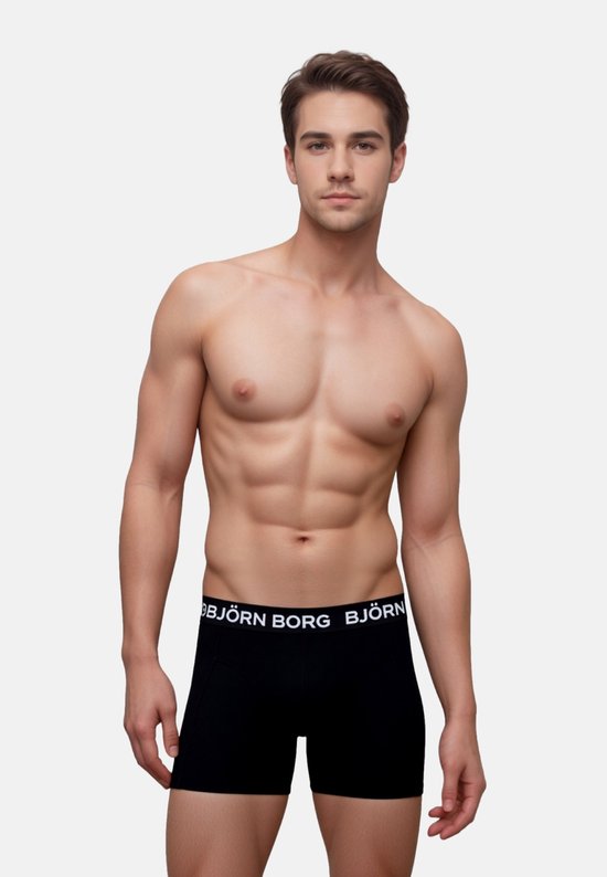 Man met gespierd bovenlichaam, draagt een zwarte Björn Borg boxer met witte merknaam.