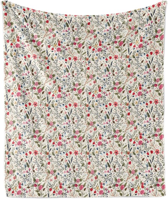 Couverture tricotée avec un fond blanc et un motif floral et de feuilles coloré avec de petites fleurs rouges et roses.