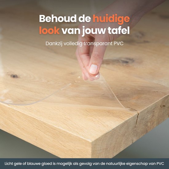 Een hand verwijdert beschermfolie van een houten tafelblad, de tafel blijft zichtbaar.