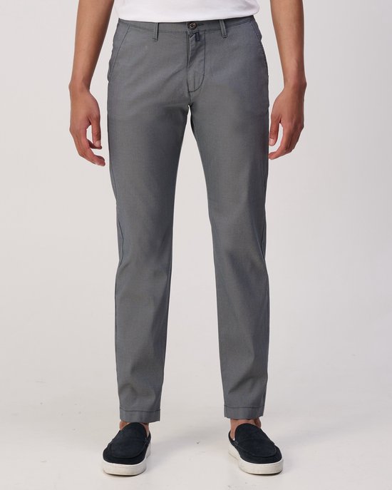 Homme portant un chino gris à micro-motifs et des chaussures slip-on sombres, vu de face.
