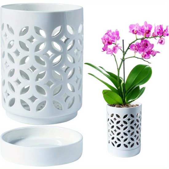 Witte pot van 14 cm hoog met decoratief lasergesneden patroon van bloembladen, met schotel, naast een orchidee.