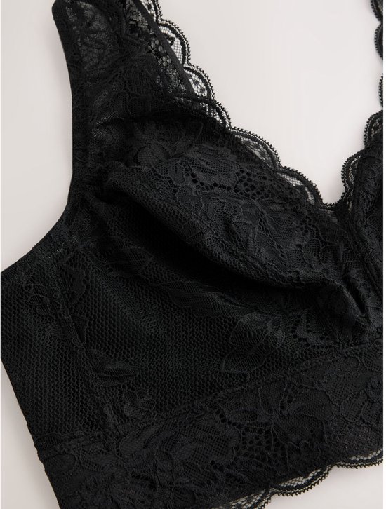 Close-up van een zwarte kanten bralette met v-hals en bloemenpatroon.
