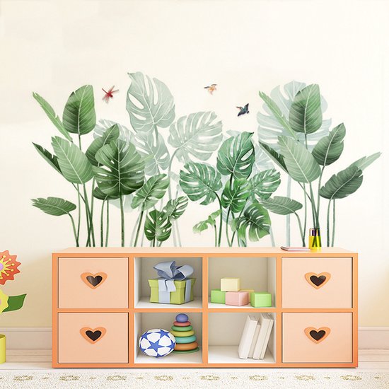Groene palm- en monstera-bladeren met drie insecten op een crèmekleurige muur, boven een oranje kast met vakken.
