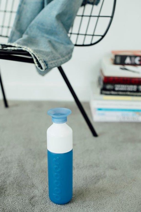 Blauwe Dopper drinkfles met witte bovenkant en blauwe dop, op een grijze vloer.
