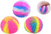 Drie koraal squeeze ballen met tie-dye patronen in roze, geel, blauw, wit en groen. Een hand houdt de bal vast.